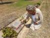 Minna kneeling beside Uncle Johnny's grave 